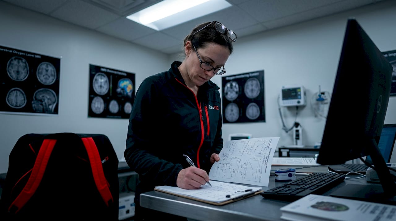 Scientist analyzing brain oxygen data in lab