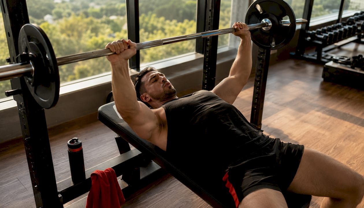 Man performing bench press with controlled breathing