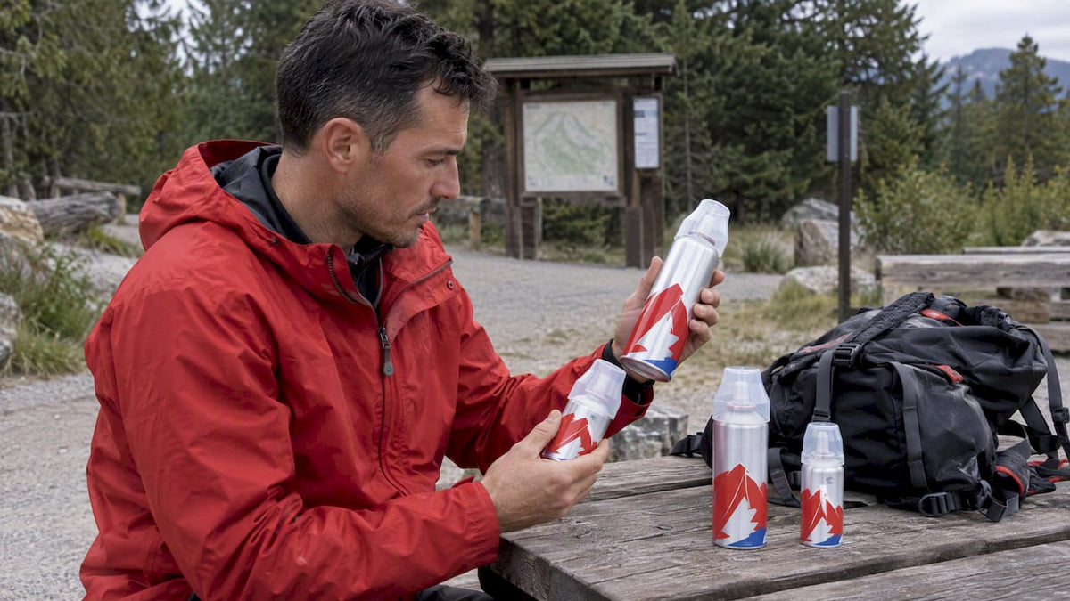 Hiker comparing REV/O2 oxygen can sizes